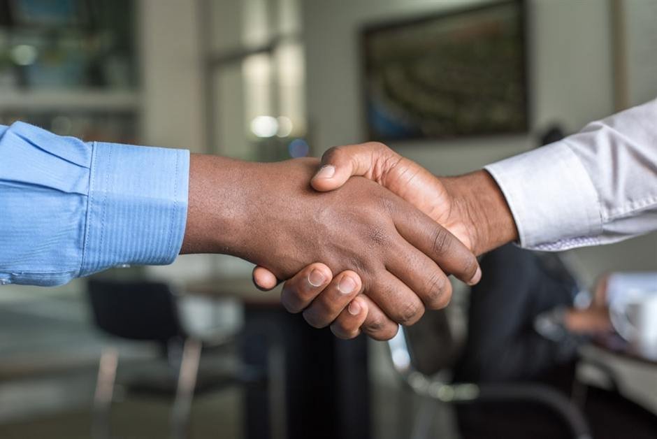 Two partners shaking hands after signing an agreement